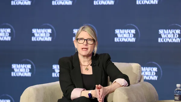 An executive speaks from her chair on stage.