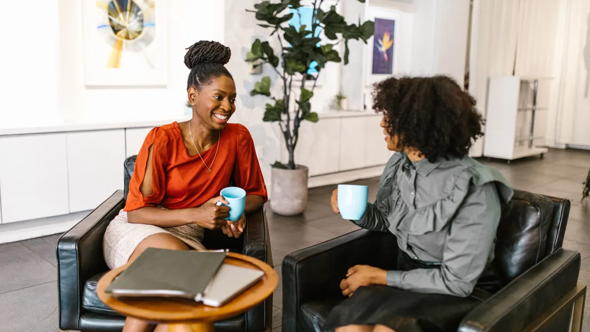 Two Black employees work together in an office