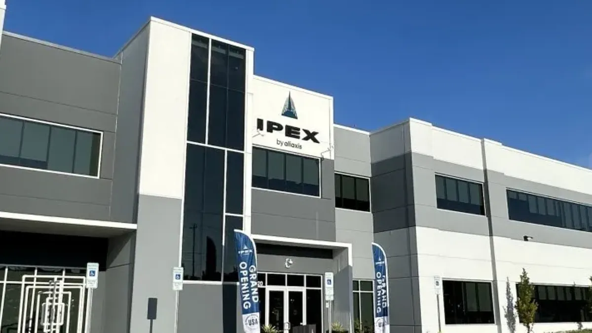 A gray and beige white building with a black Ipex sign in the center.