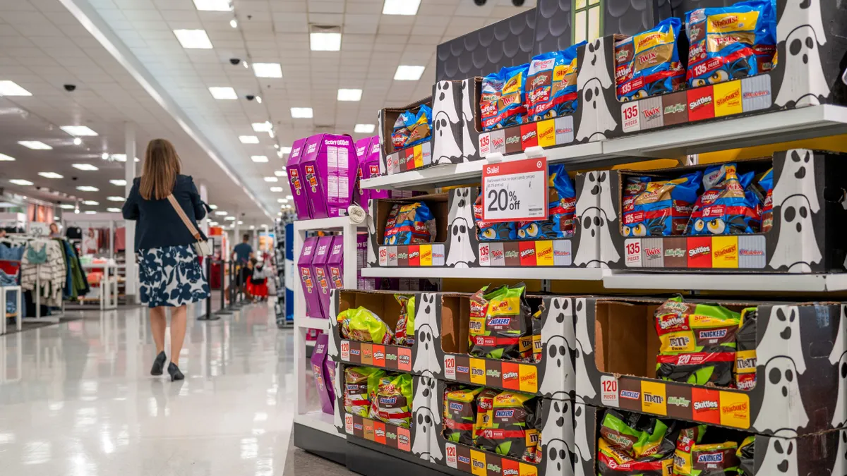 A person is shopping in a Target near shelves of Halloween candy.
