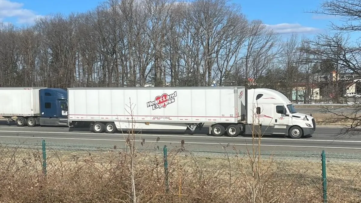 A Heartland trailer on I-95 next to another truck.