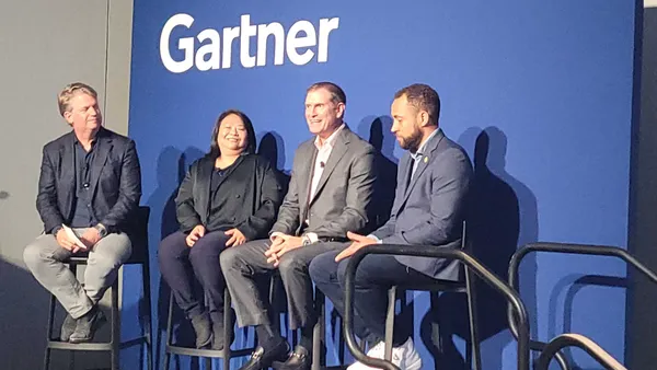 four executives speaking during a conference