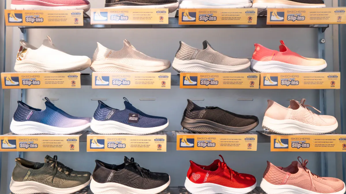 A wall display of multiple Skechers sneakers in a store.