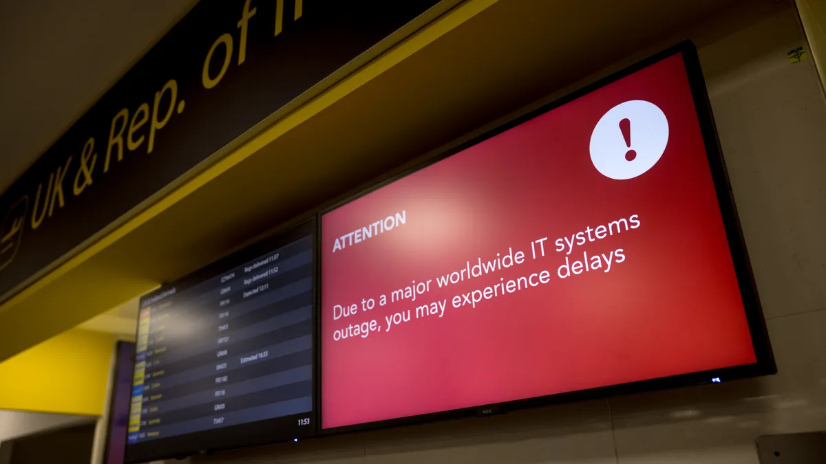 A screen warns airport passengers of potential delays due to a worldwide IT systems outage