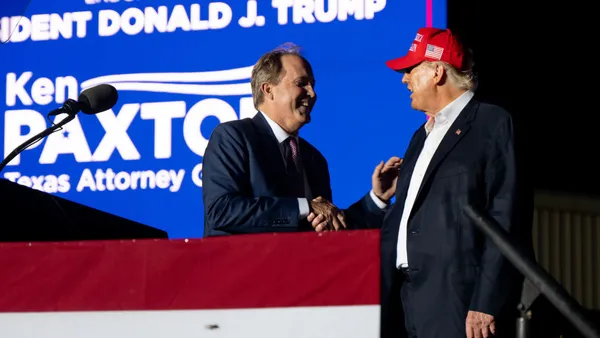 Ken Paxton shakes Donald Trump's hand at a campaign rally