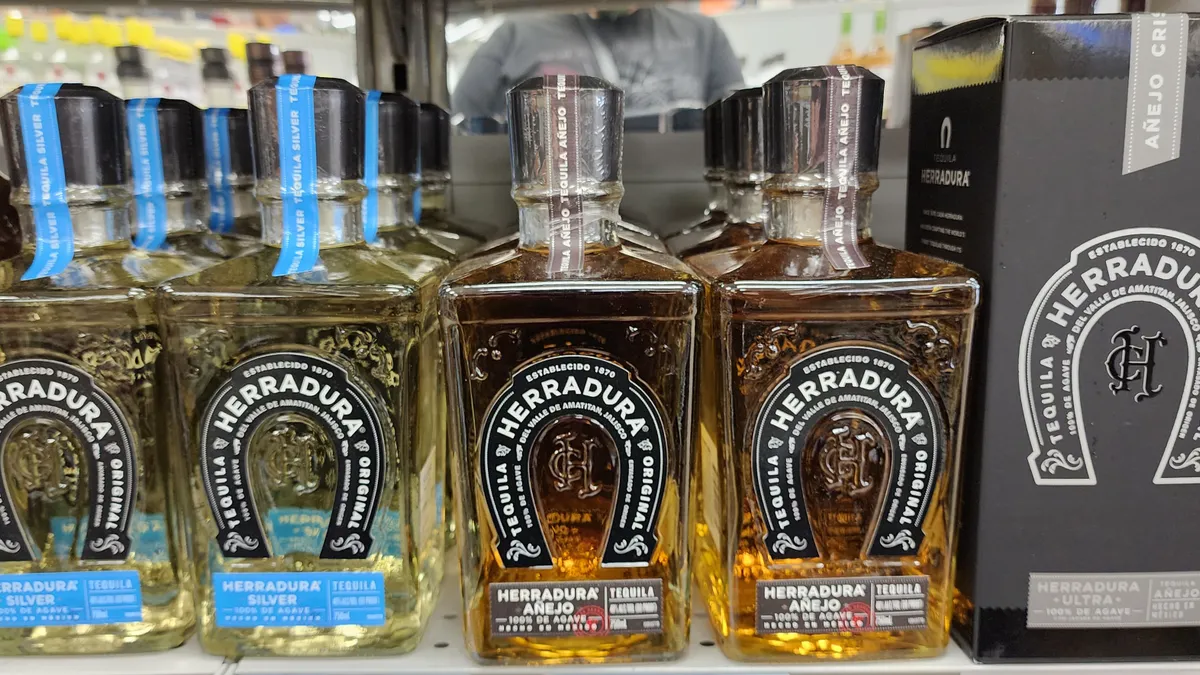 Bottles of Herradura Silver and Añejo, and a black Herradura ultra box on a shelf.