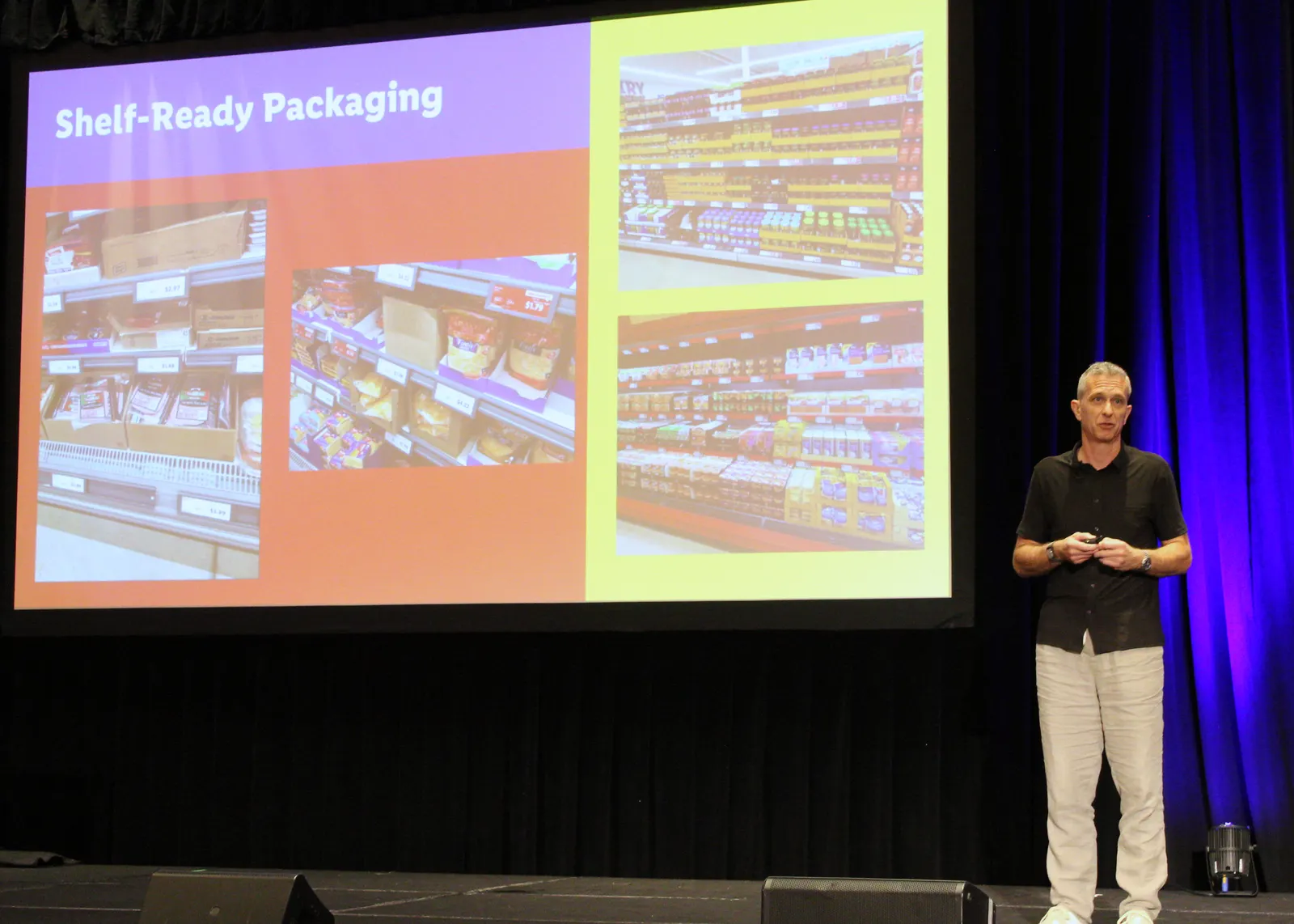 A speaker stands on stage in front of a large screen showing grocery shelves and a title that says "Shelf-Ready Packaging."