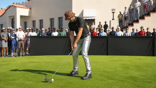 An in-game avatar plays golf while wearing foil pants, a bucket hat and polo.
