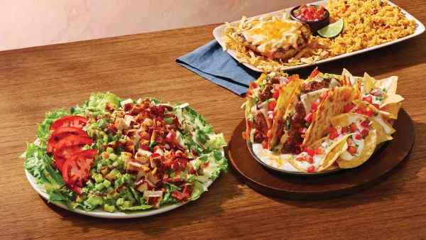 A table with a salad, cheeseburger quesadilla and a plate of rice