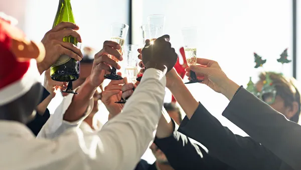 Close-up of multiethnic group of corporate executives raising their glasses to toast their success at year-end.