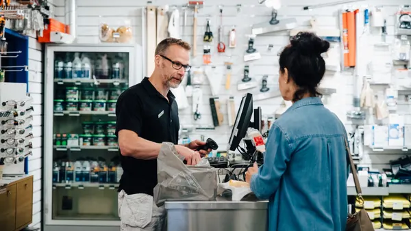 Retailer and customer interacting as customer is checking out at a hardware store.