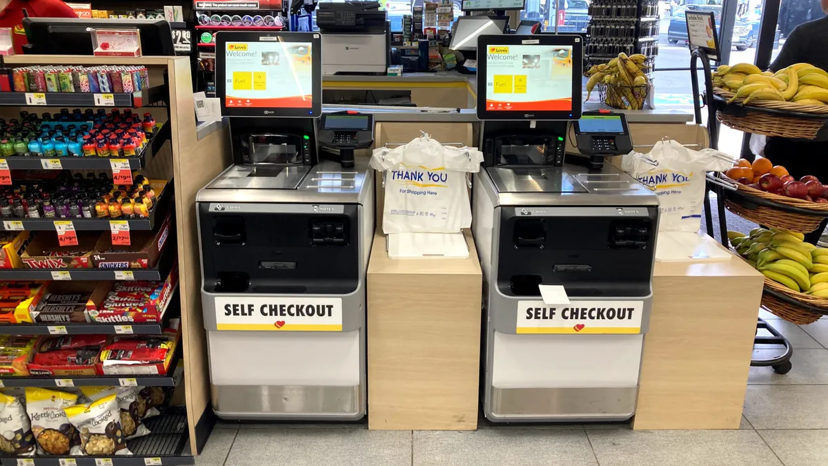 A photo of self checkout kiosks inside a convenience store. Each machine says "self checkout."