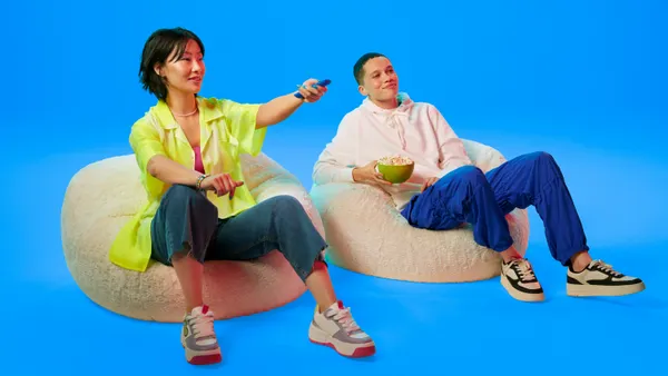 People sitting on bean bags with a blue screen behind