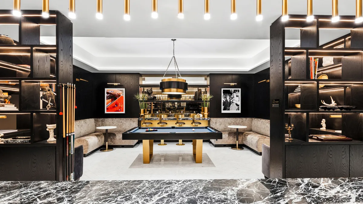 A white room with dark shelves and a pool table.