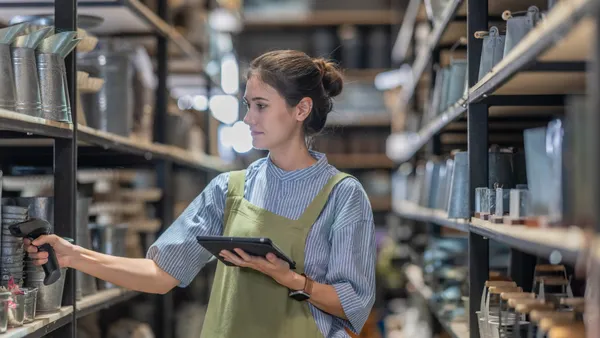 A woman verifies inventory with a handheld scanner