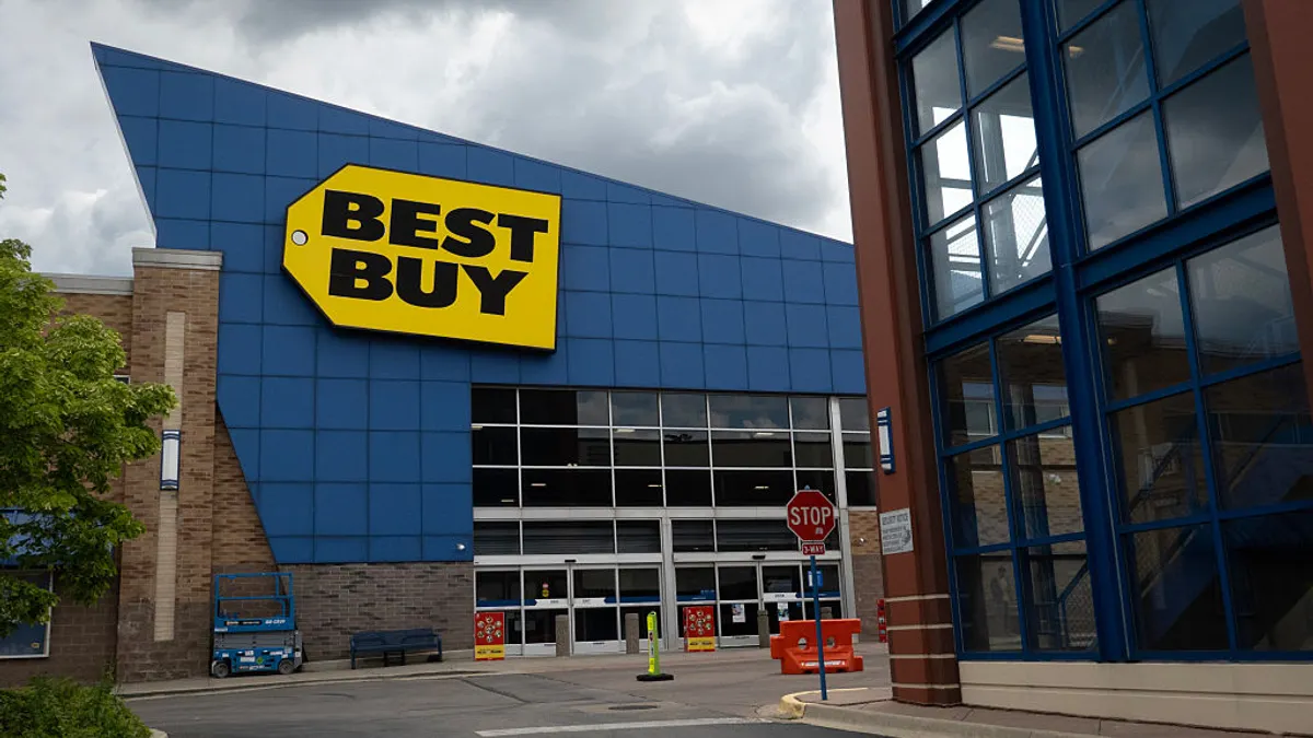 An exterior photo of a store with the Best Buy logo on a cloudy day.
