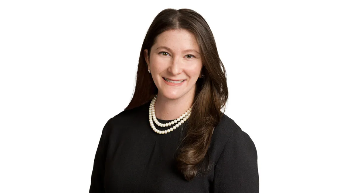 Dana Perlman smiles for a professional headshot against a white backdrop.