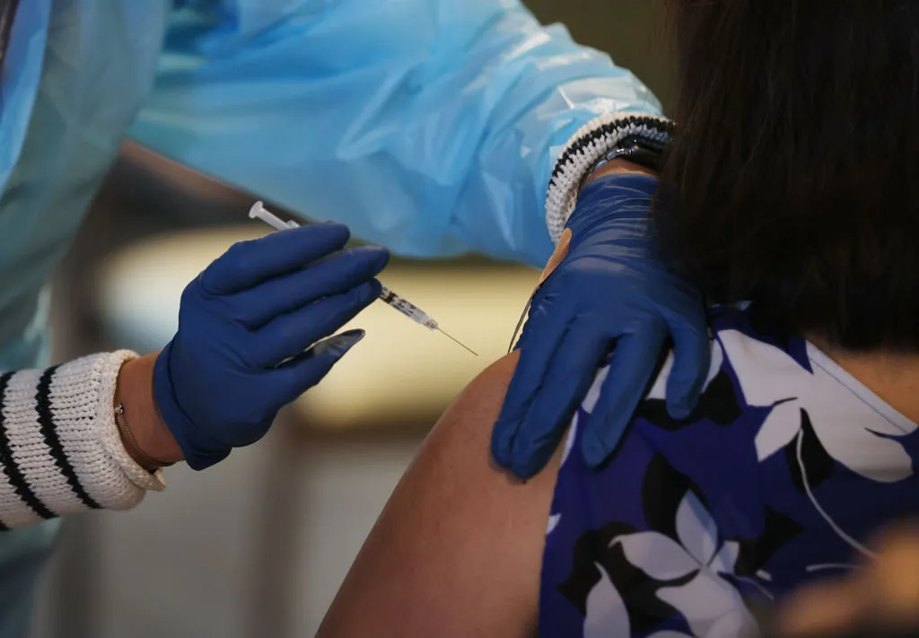 A medical professional administers a COVID-19 vaccine for a patient.