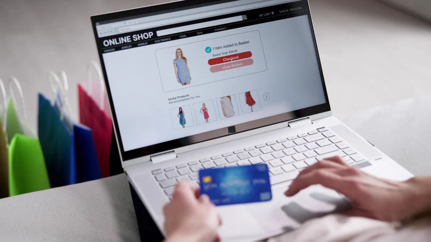 “Person shopping online with a laptop and holding a credit card