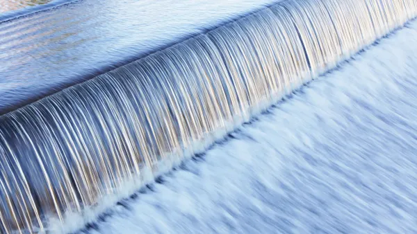 Water rushing over the edge of a dam.