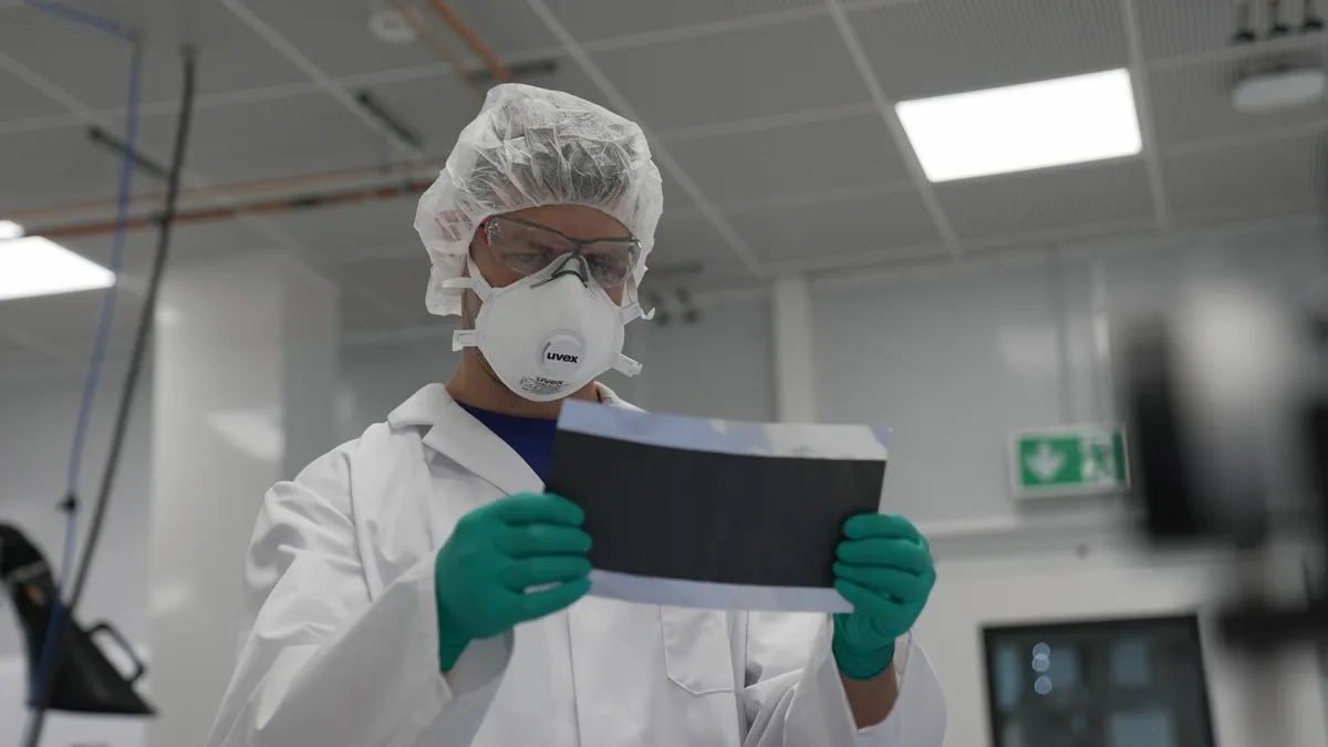 An engineer inspects dry coating battery material at PowerCo laboratories