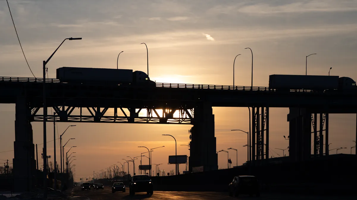 Trucks drives across a bridge.