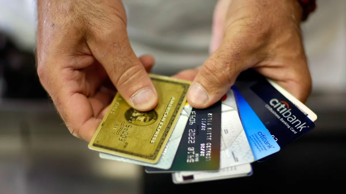 Two hands holding credit cards.