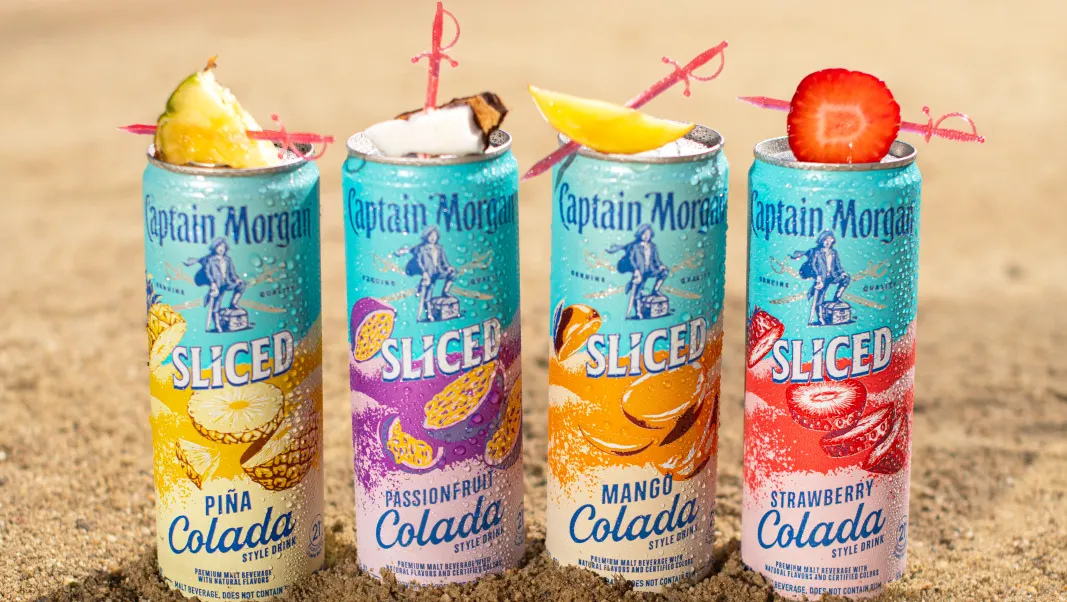 Four cans of Captain Morgan ready-to-drink beverages are pictured in sand.