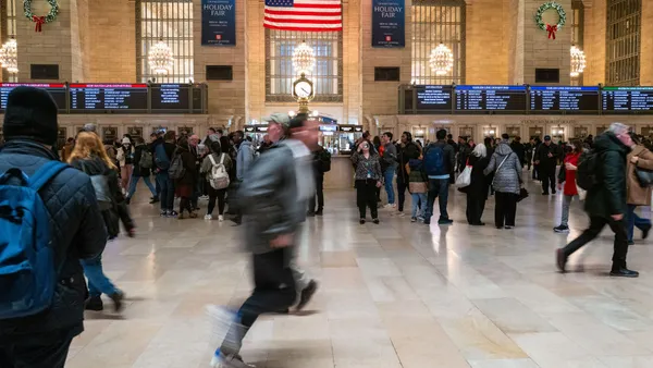 A traveler is blurry as he rushes through a station.