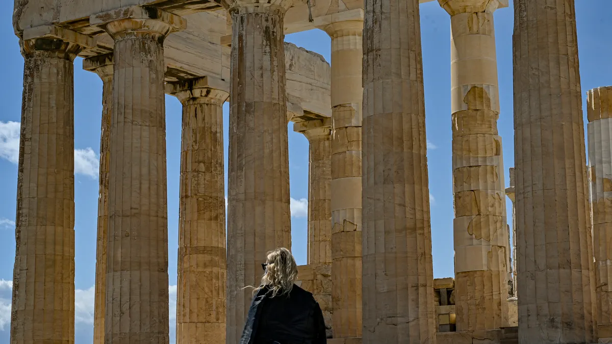 Parthenon in Athens with person in front of structure.