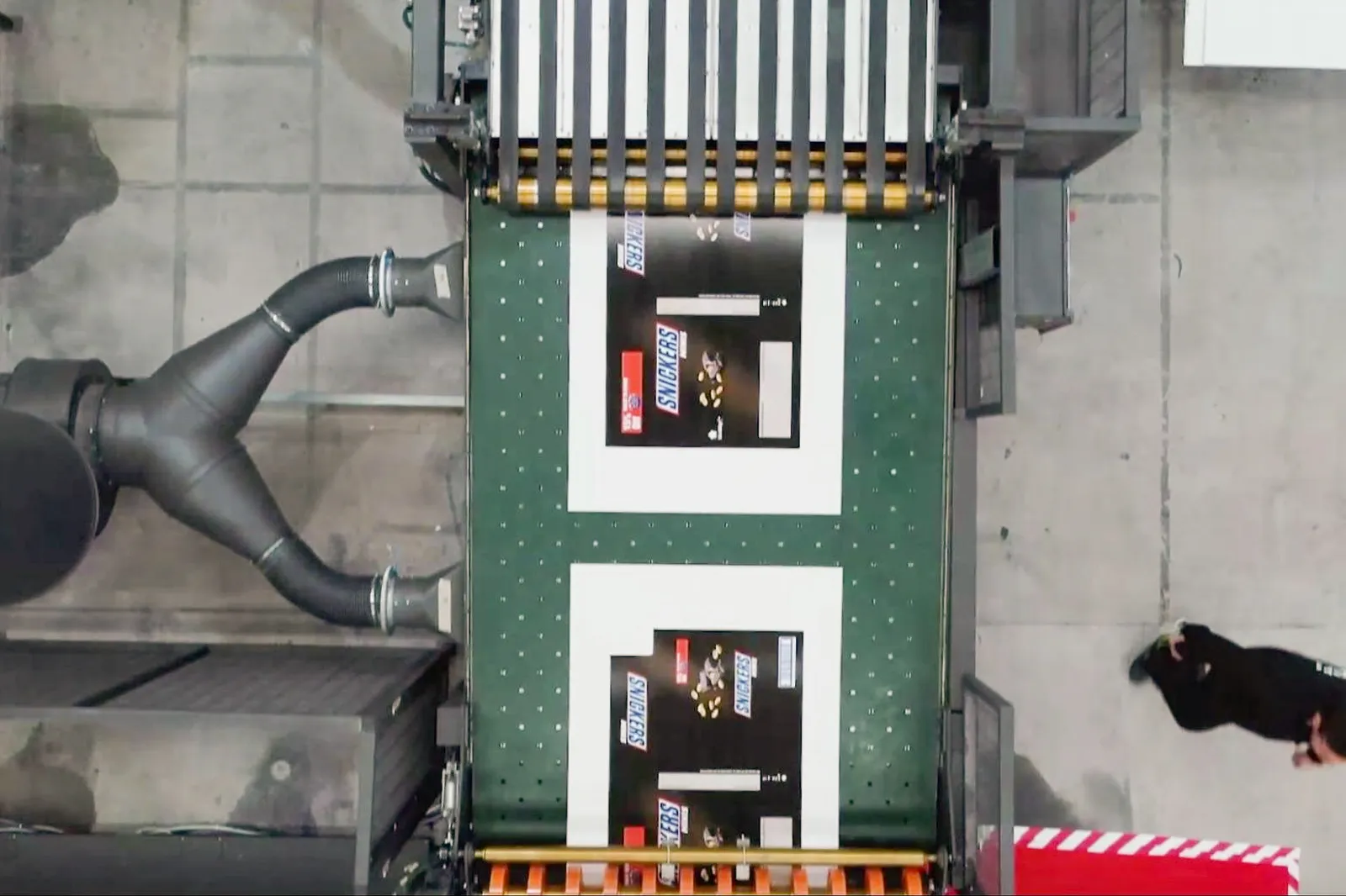 Aerial view of brightly colored printed packaging on an industrial conveyor belt.