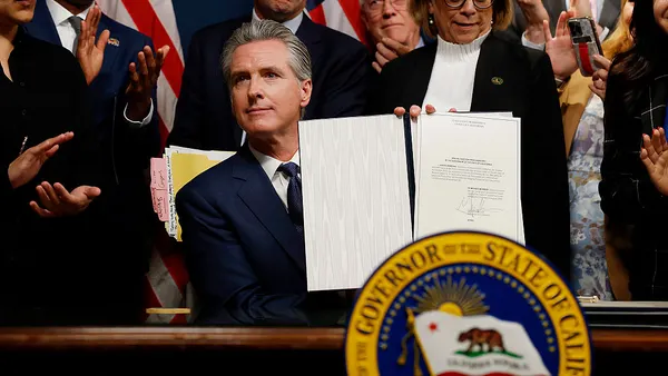 California Gov. Gavin Newsom seen holding a signed bill.