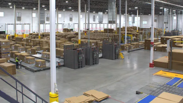 An aerial view of hundreds of stacks of flat corrugated boxes and pallets in an industrial facility.