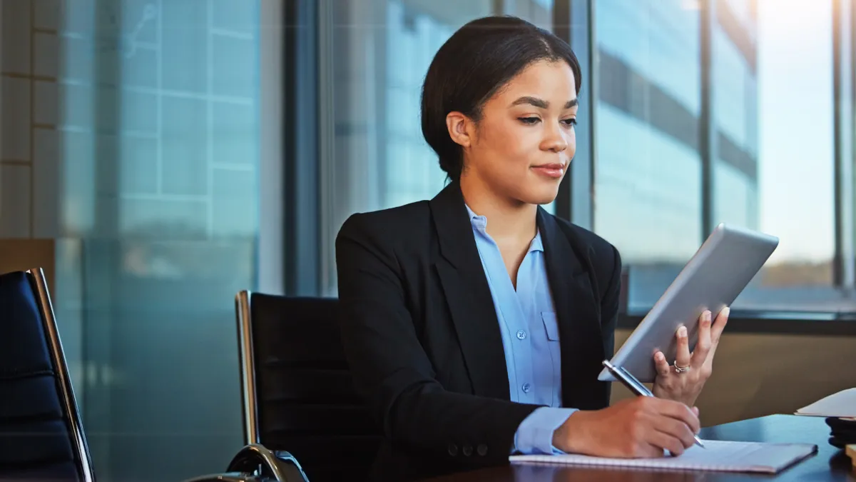 A lawyer views a tablet while sitting in her office