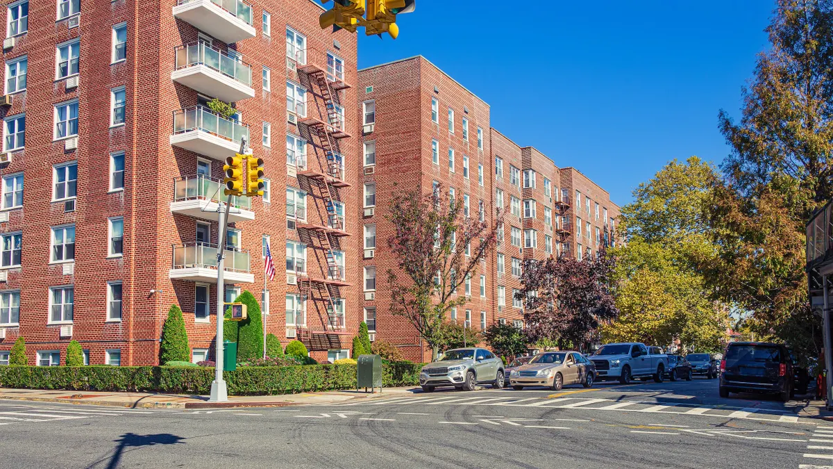 Brick buildings on a tree-lined street.