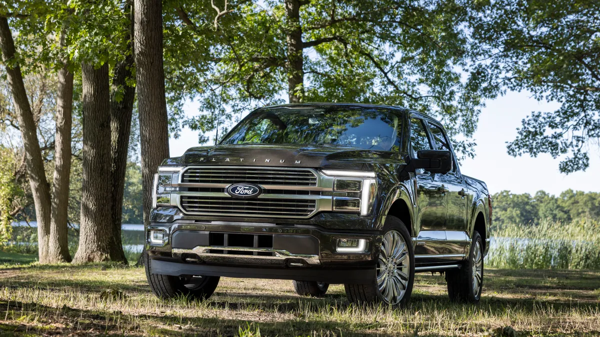 The 2024 Ford F-150 Platinum pickup outdoors with trees in the background.