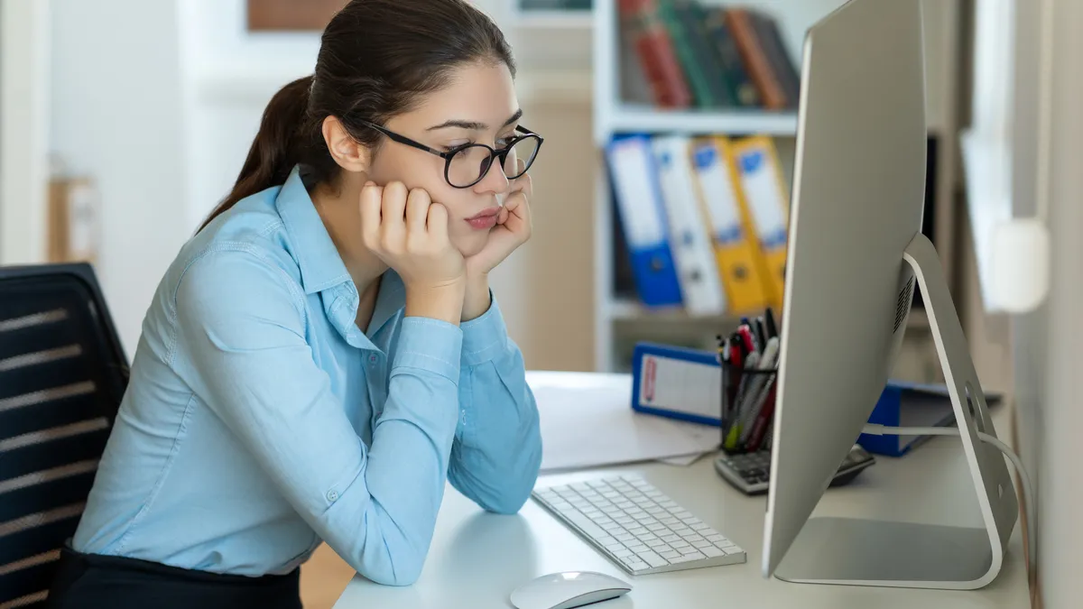 Person at computer looks dejected.