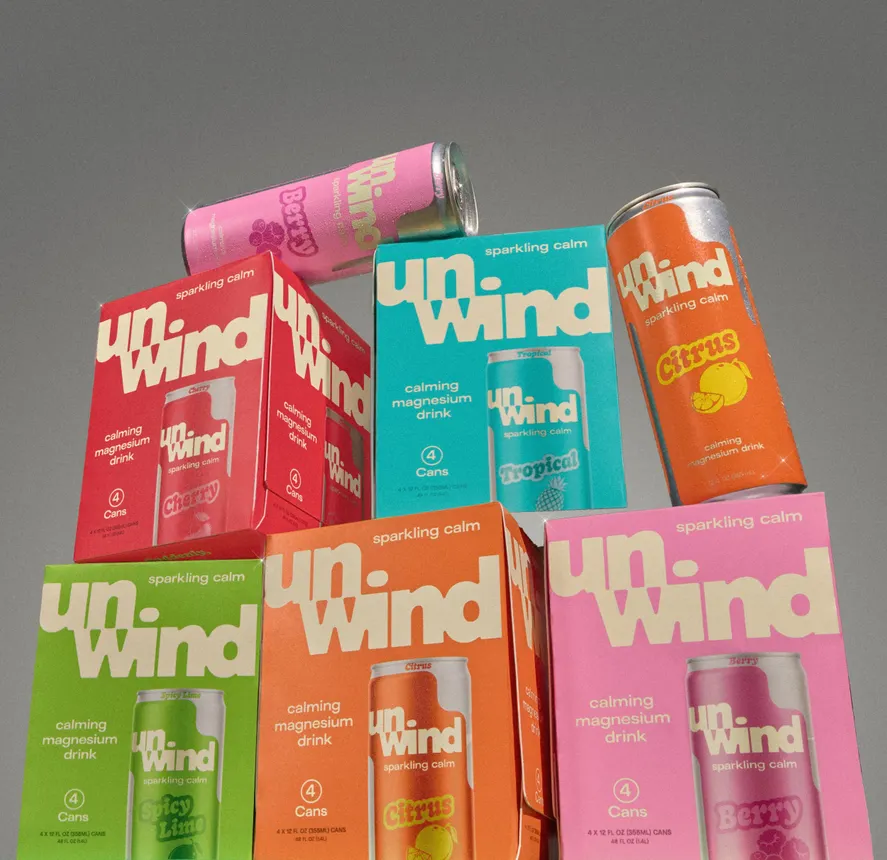 Cans of Unwind in different colors are stacked on top of each other.