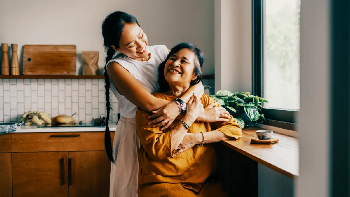 Two people embracing at home.