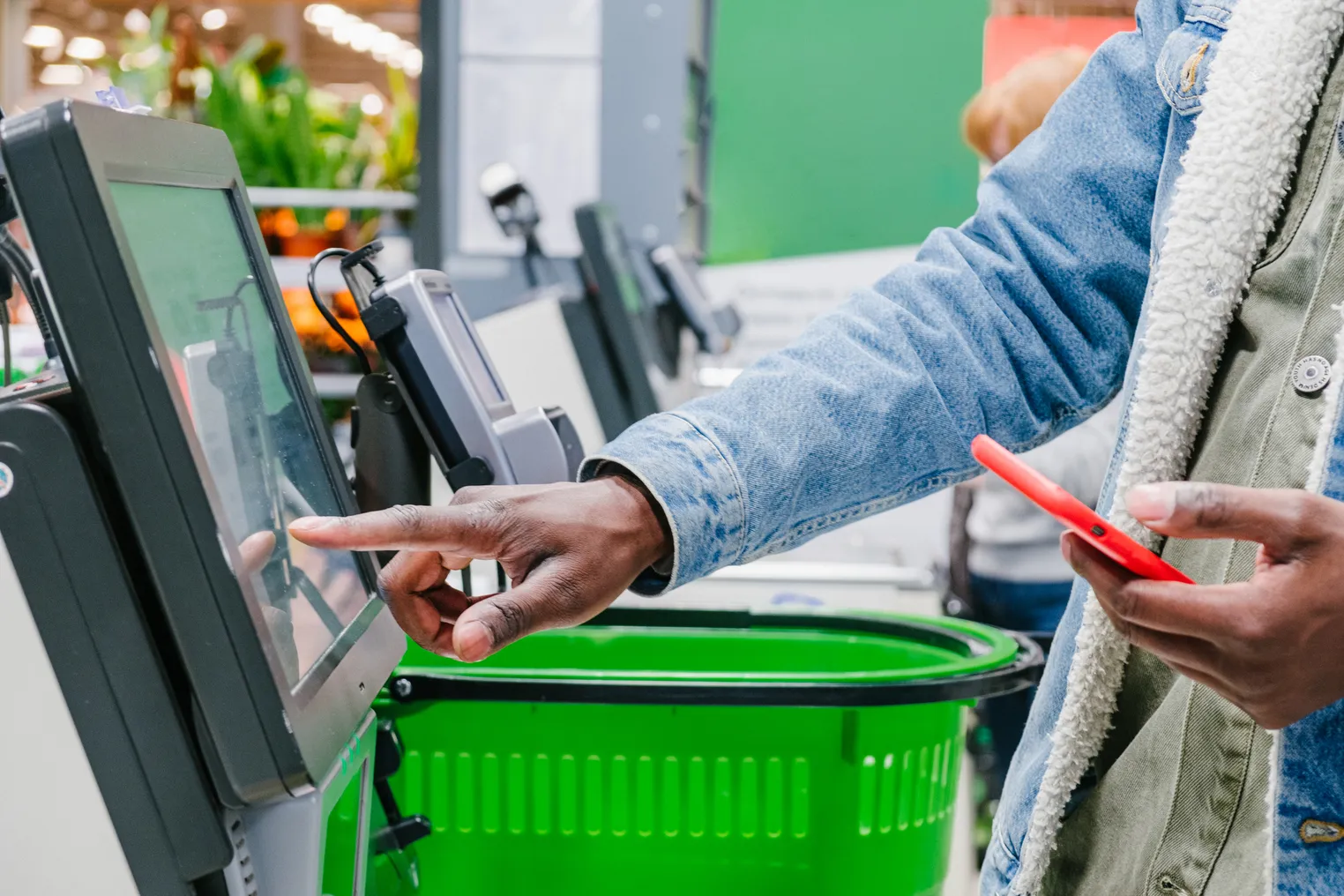 Person using a self-checkout station at a supermarket