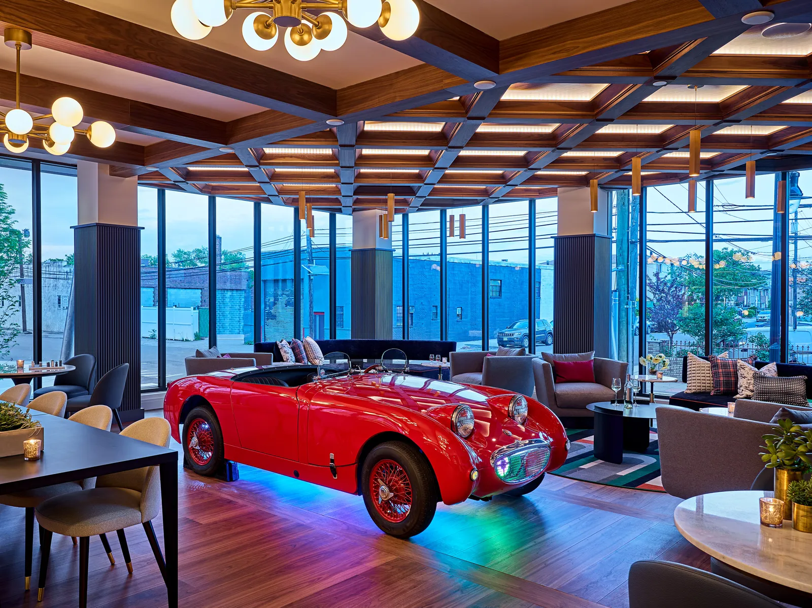 A lounge with a tiny red sports car in it.