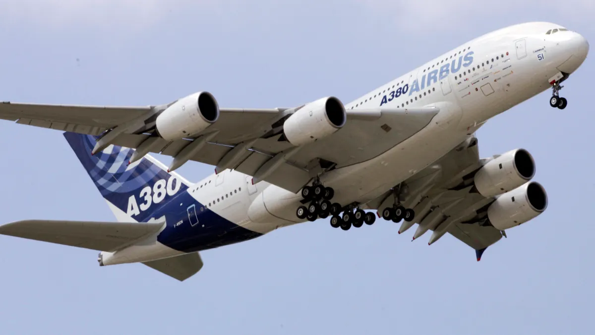 An airplane with the words "A-380 Airbus" written on it flies in the air.