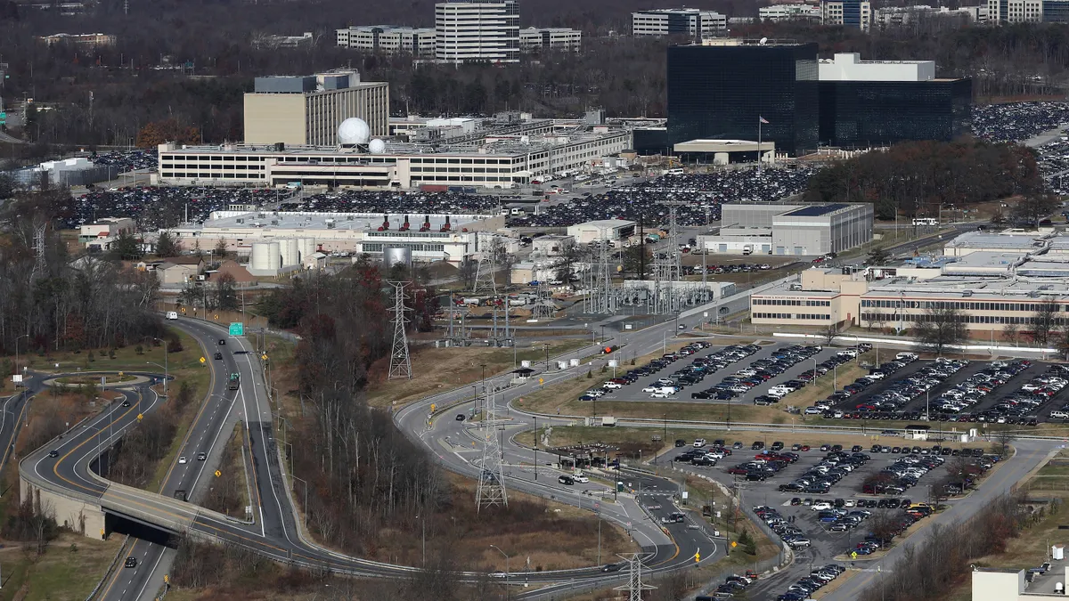 An aerial view shows a series of buildings, parking lots, and highways