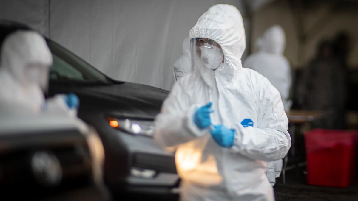 Medical technicians work with patients at a COVID-19 Community-Based Testing Site at the PNC Bank Arts Center in Holmdel, N.J., March 23, 2020. The testing site, established in partnership with the Fe