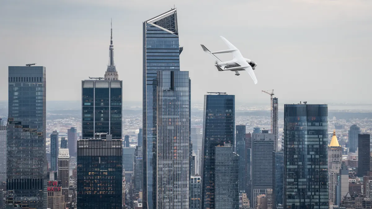 Airplane flies over tall buildings.