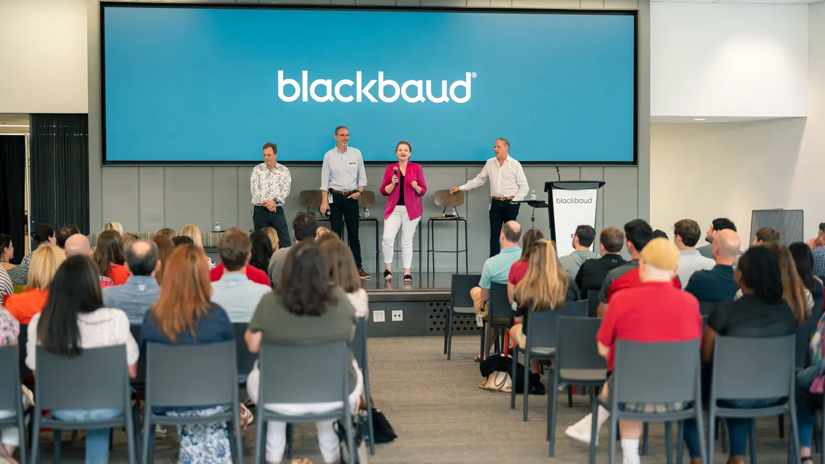 Blackbaud executives on stage during company meeting