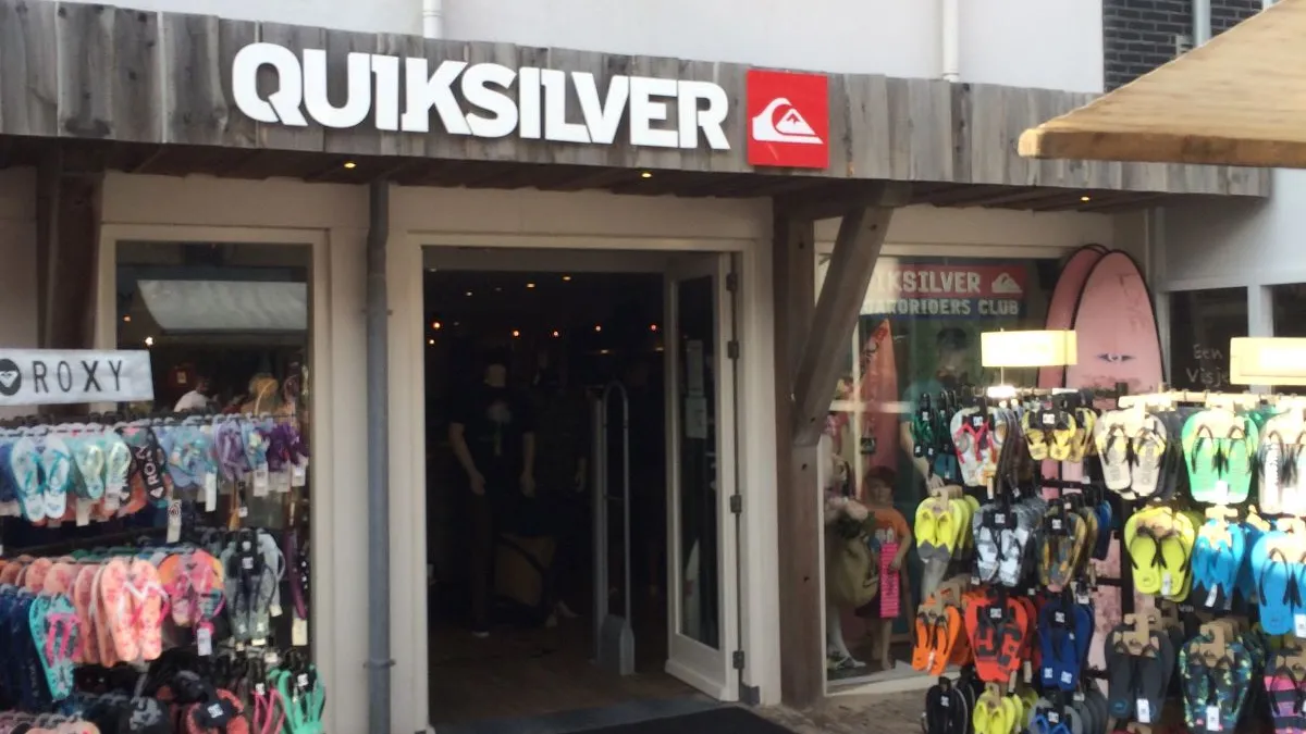 A Quiksilver storefront, with racks of flip flops outside.