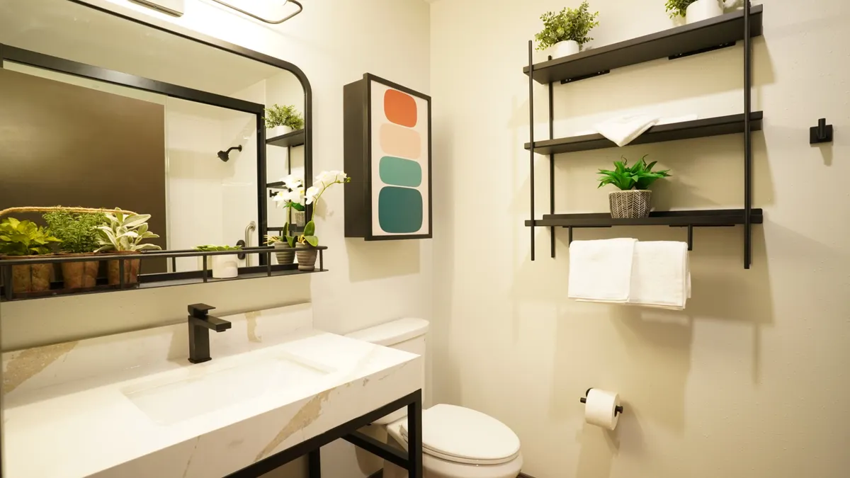 An image shows inside a guestroom bathroom at a Studio 6 Plus hotel.