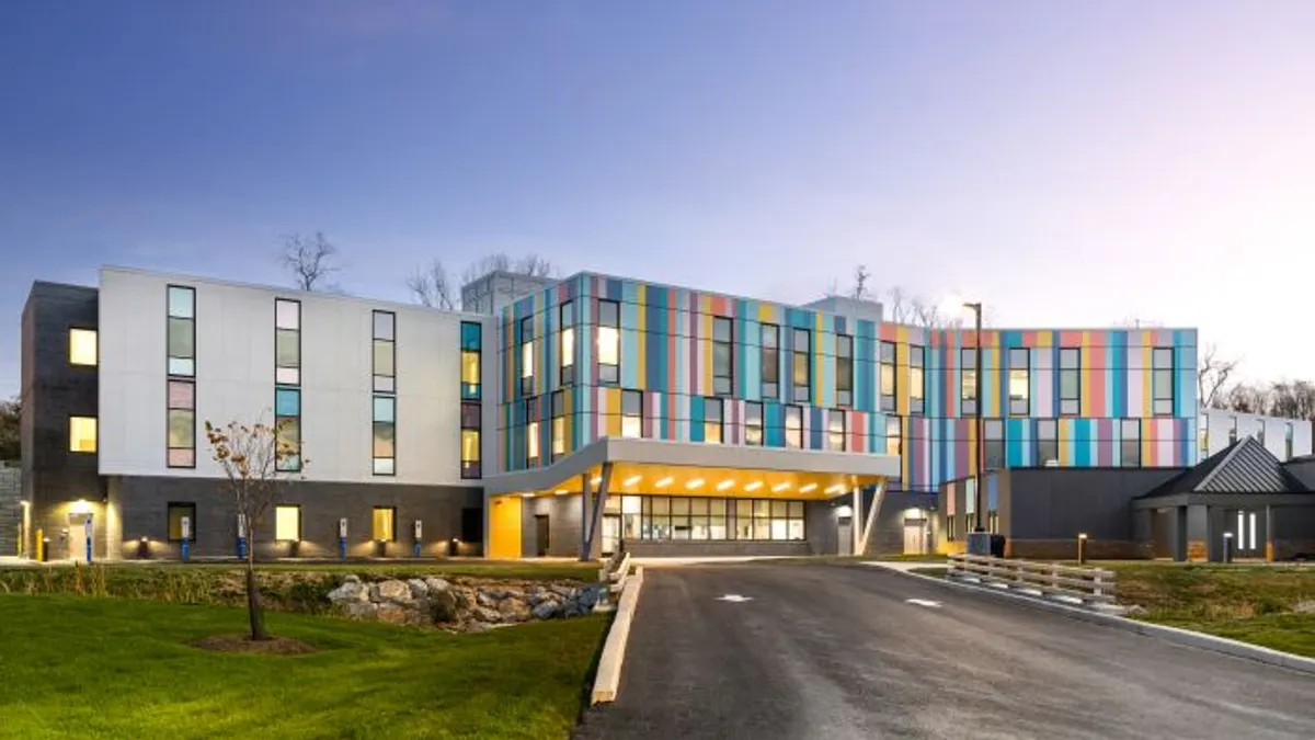 A photograph shows a colorful, newly built psychiatric hospital.