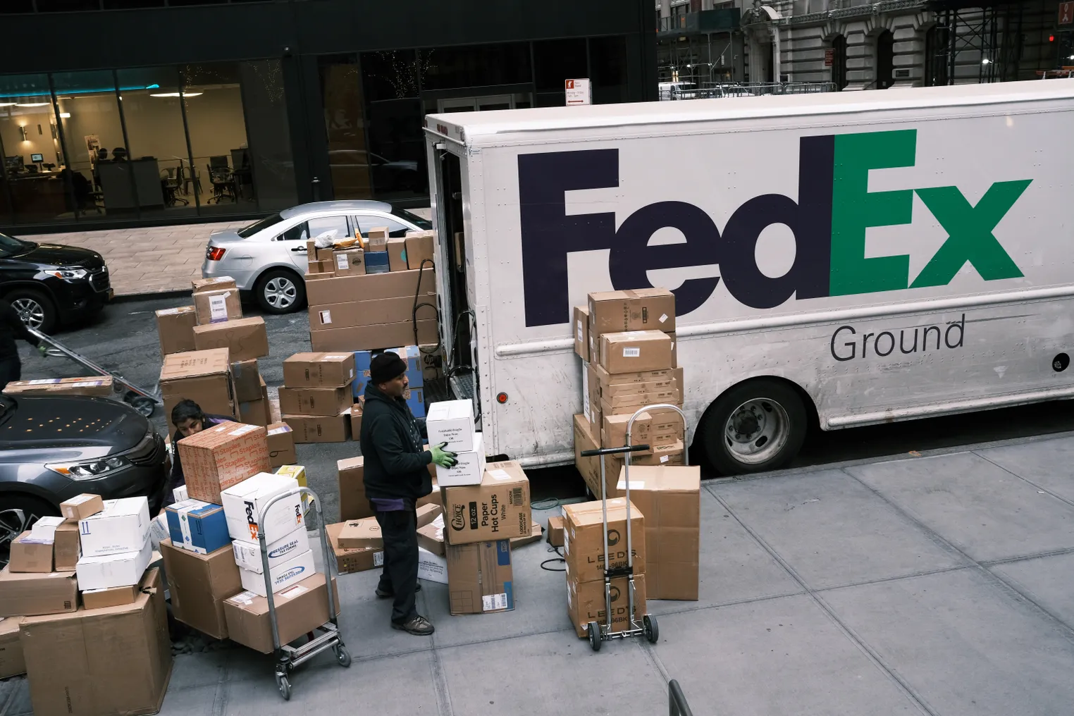 A FedEx employee sorts boxes on the sidewalk on November 21, 2019 in New York City.